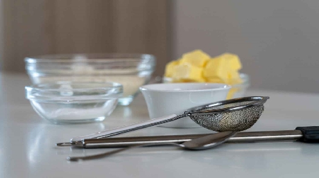 Homemade hash butter cooling in a glass container on a kitchen surface